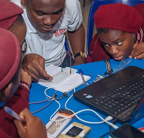 Copiii învață despre circuitele electronice, luând notițe și manifestând un mare interes pentru subiect.