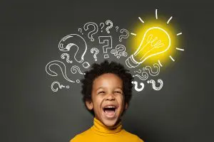 Laughing,Child,Boy,Student,With,Lightbulb,And,Question,Marks.,Brainstorming