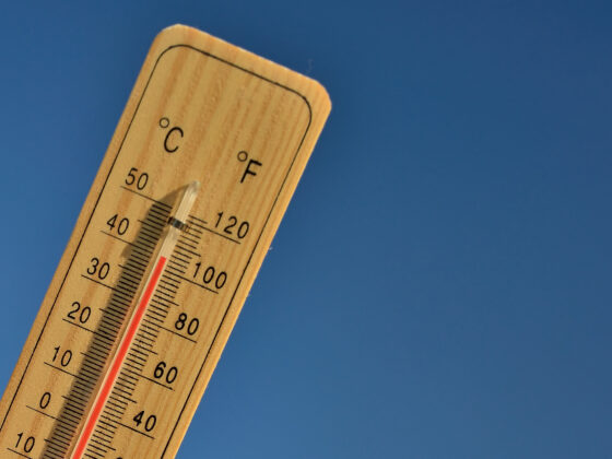 Mercury wooden thermometer shows very high temperature. Temperatures in Celsius and Fahrenheit degrees. Hot summer weather. Forty degrees over zero during the day.