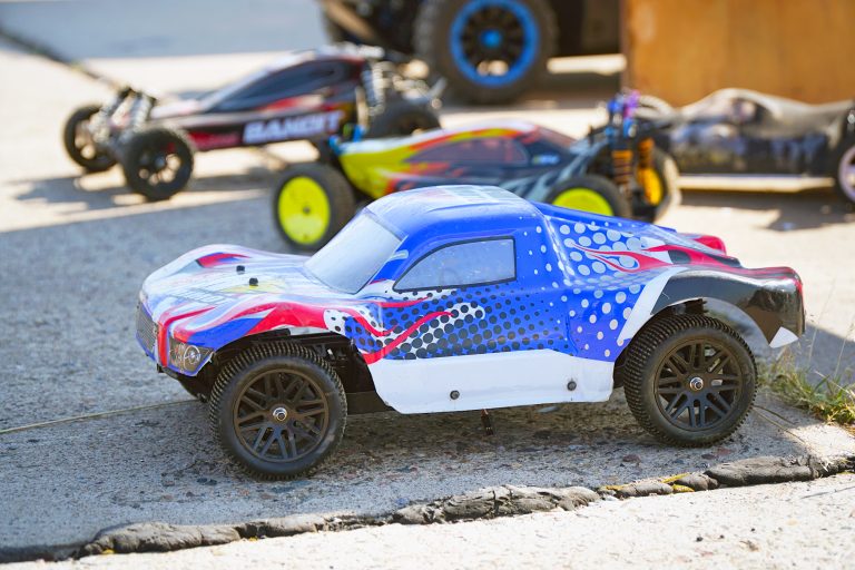 Radio-controlled racing plastic car toy on asphalt