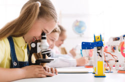 Матично образование. Девојка што гледа микроскоп со робот во близина