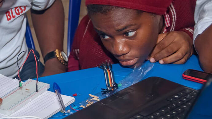 Kids learning about electronic circuits, taking notes and showing great interest in the subject.