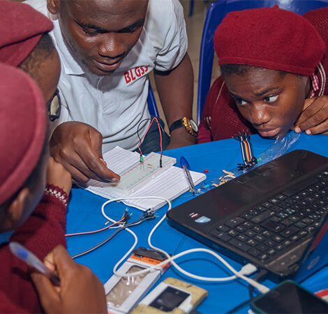 Kids learning about electronic circuits, taking notes and showing great interest in the subject.